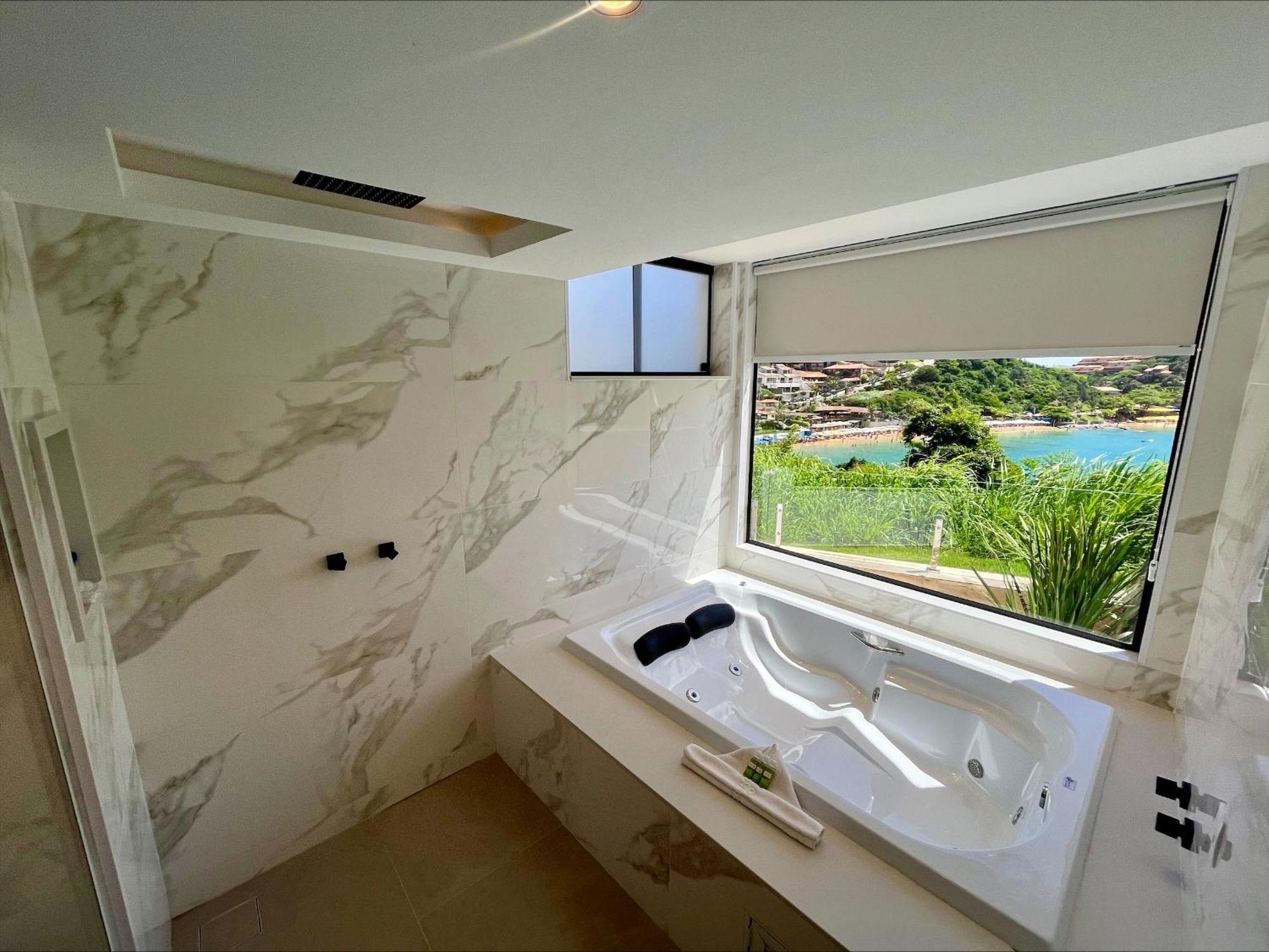 Suíte master com banheira de hidromassagem e vista do mar